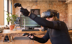 Man using a virtual reality HMD and handheld controllers with full-body motion capture